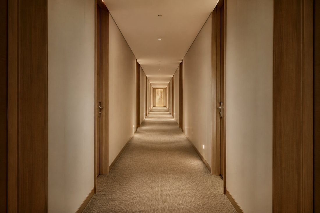 Corredor longo de hotel com portas em enfiada